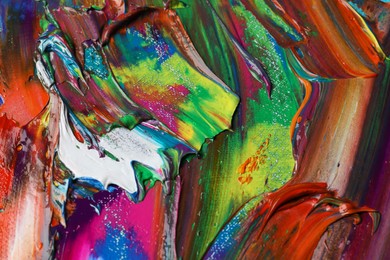 Photo of Strokes of colorful acrylic paints as background, closeup view