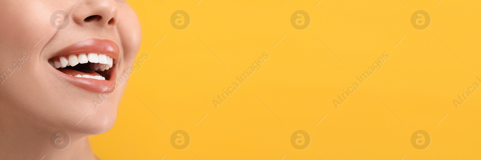 Image of Woman with clean teeth smiling on orange background, closeup. Banner design with space for text