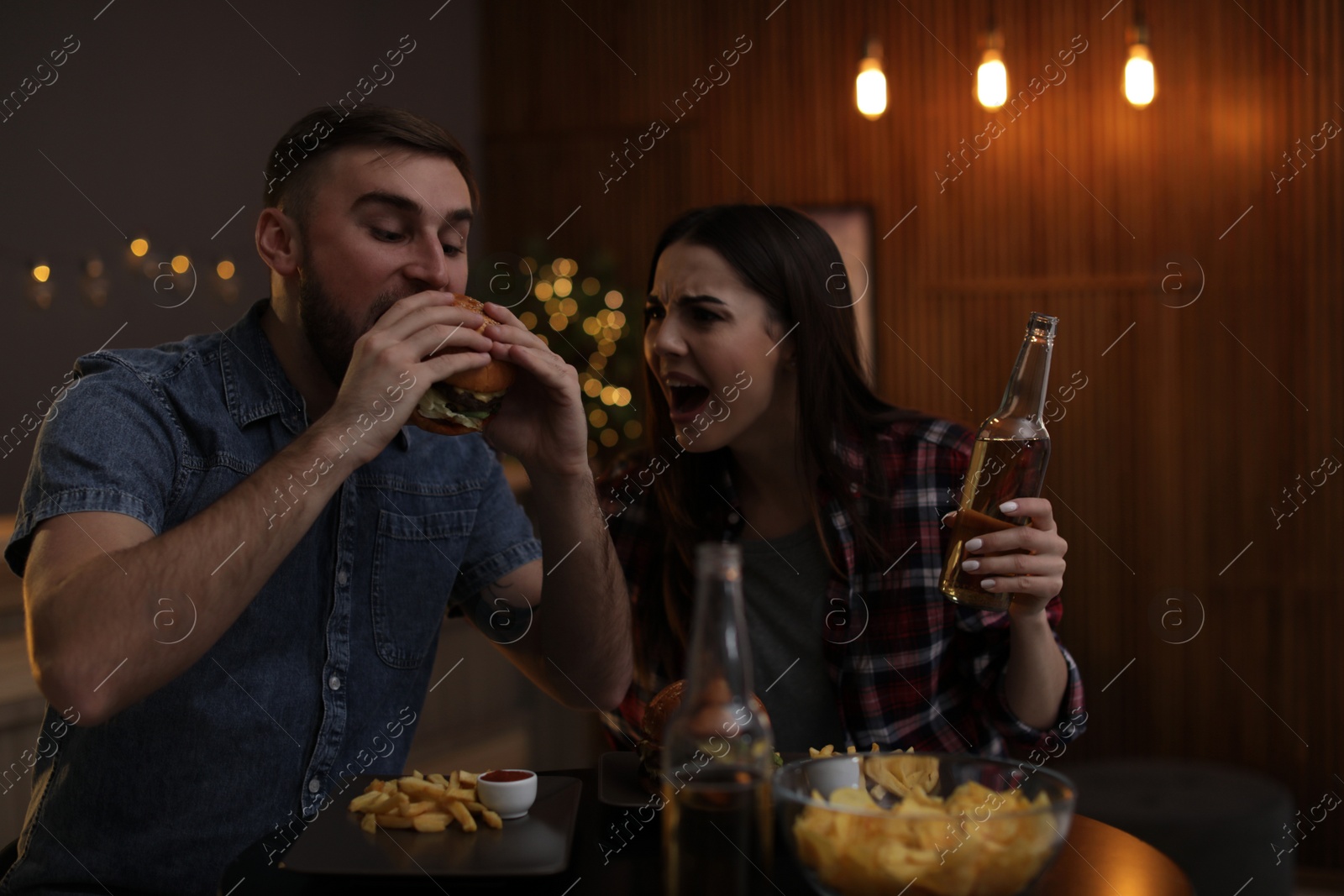 Photo of Young couple having lunch in burger restaurant
