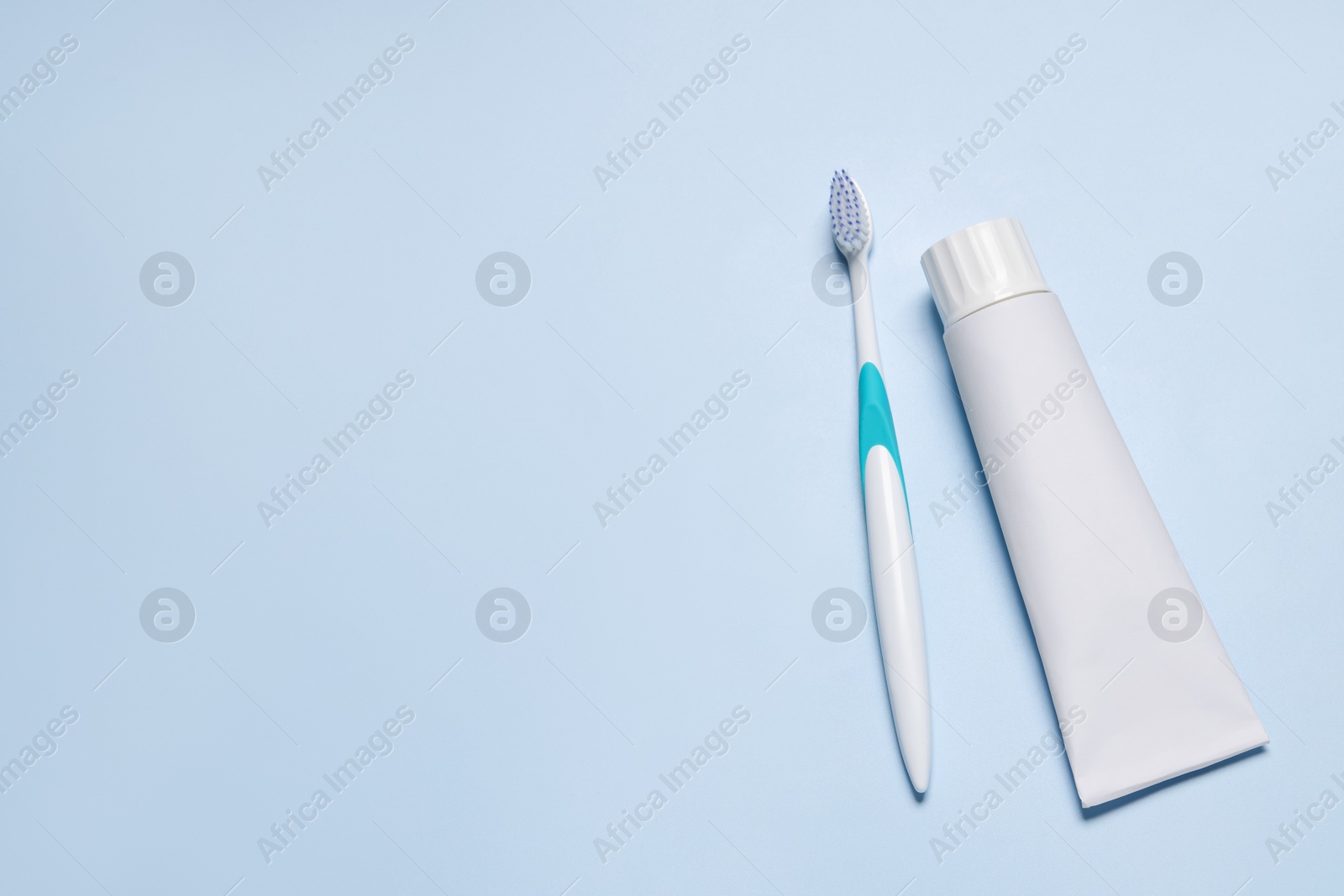 Photo of Plastic toothbrush and paste on light background, flat lay. Space for text