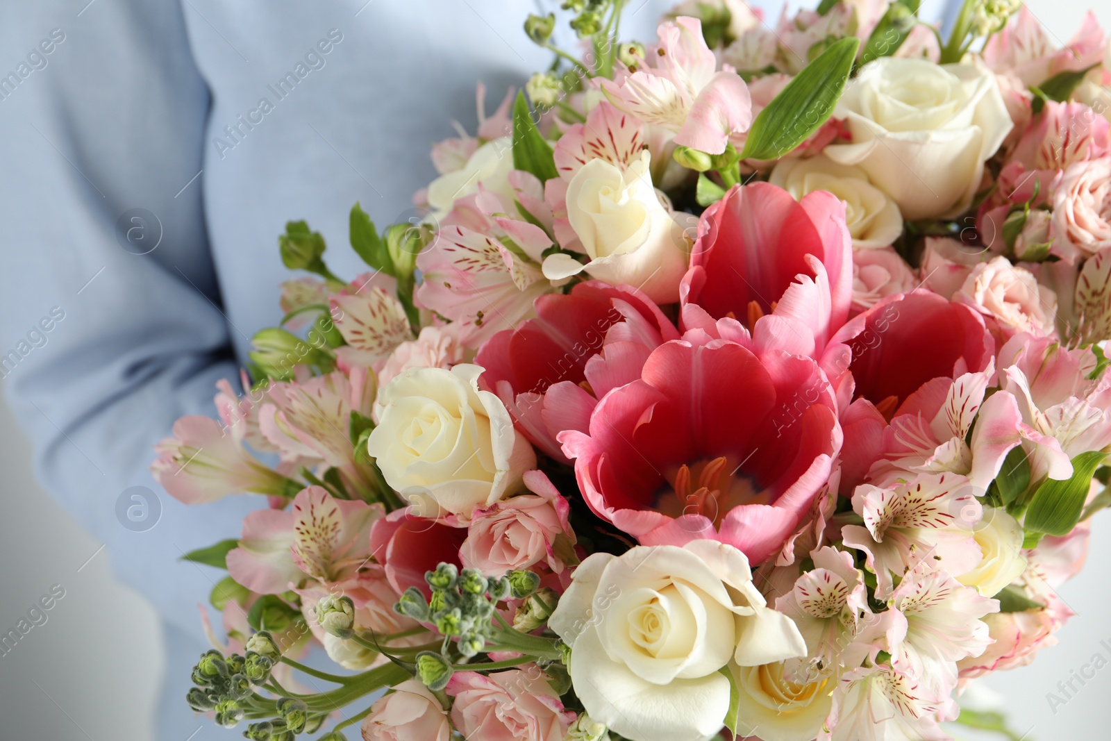 Photo of Woman with beautiful bouquet of fresh flowers on light background, closeup