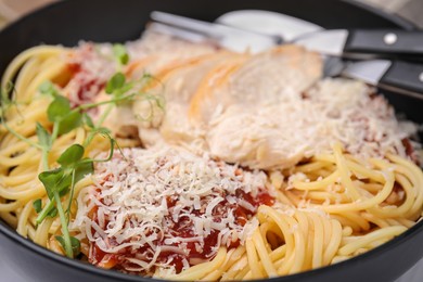 Photo of Delicious pasta with tomato sauce, chicken and parmesan cheese in bowl, closeup