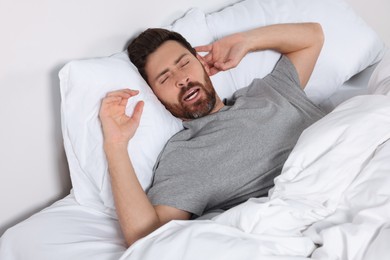 Photo of Man sleeping on comfortable pillows in bed at home