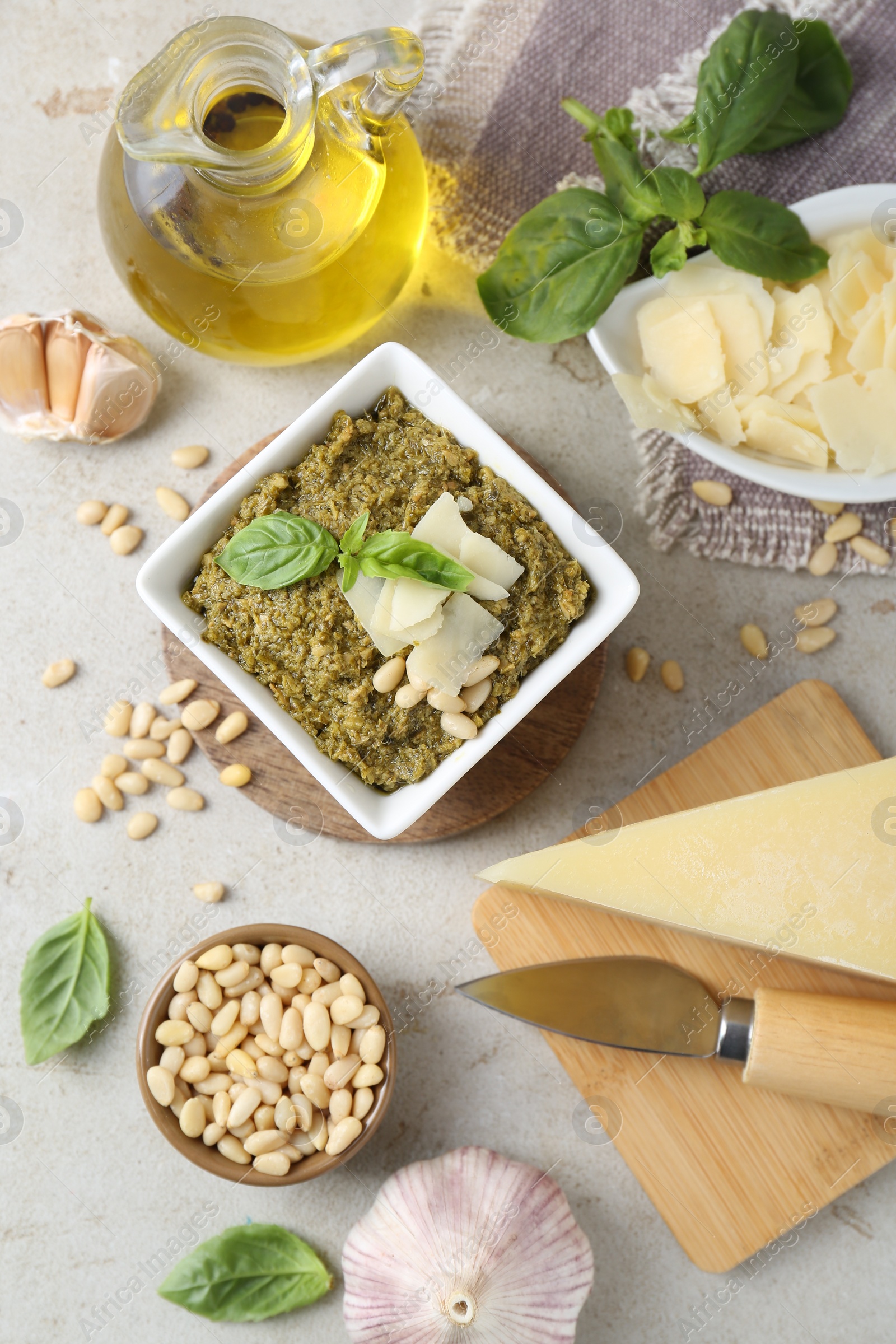 Photo of Delicious pesto sauce and ingredients on light table, flat lay