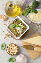 Delicious pesto sauce and ingredients on light table, flat lay