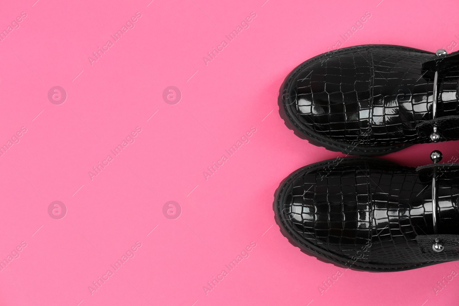 Photo of Pair of stylish ankle boots on pink background, top view. Space for text