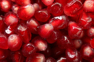 Photo of Ripe juicy pomegranate grains with water drops as background, top view