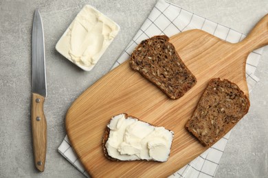 Photo of Delicious cream cheese and bread on grey table, flat lay