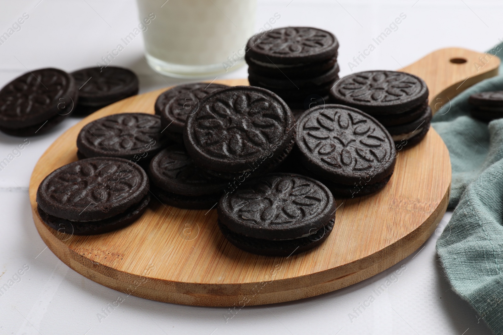 Photo of Board with tasty sandwich cookies on white table, closeup