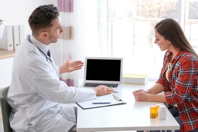 Photo of Male doctor consulting patient in clinic