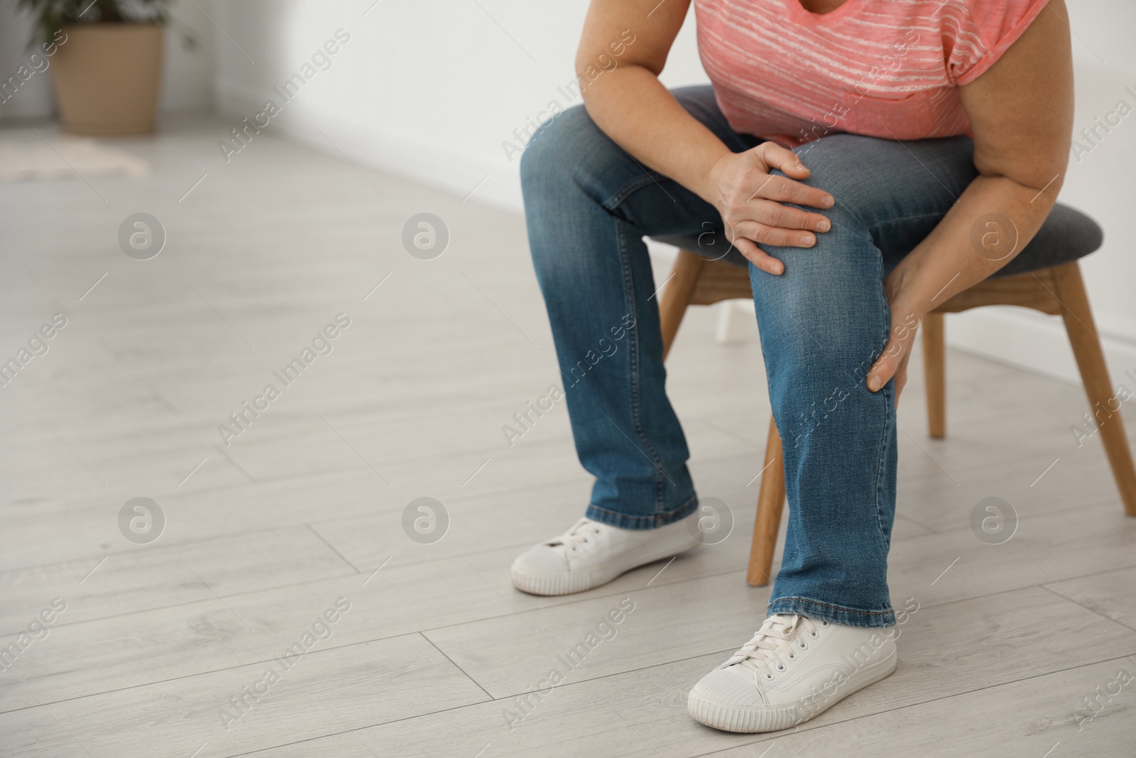 Photo of Mature woman suffering from leg pain at home, closeup. Space for text