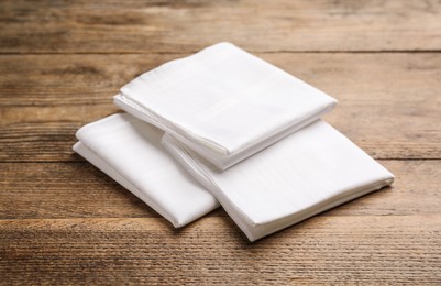 Photo of Three white handkerchiefs folded on wooden table