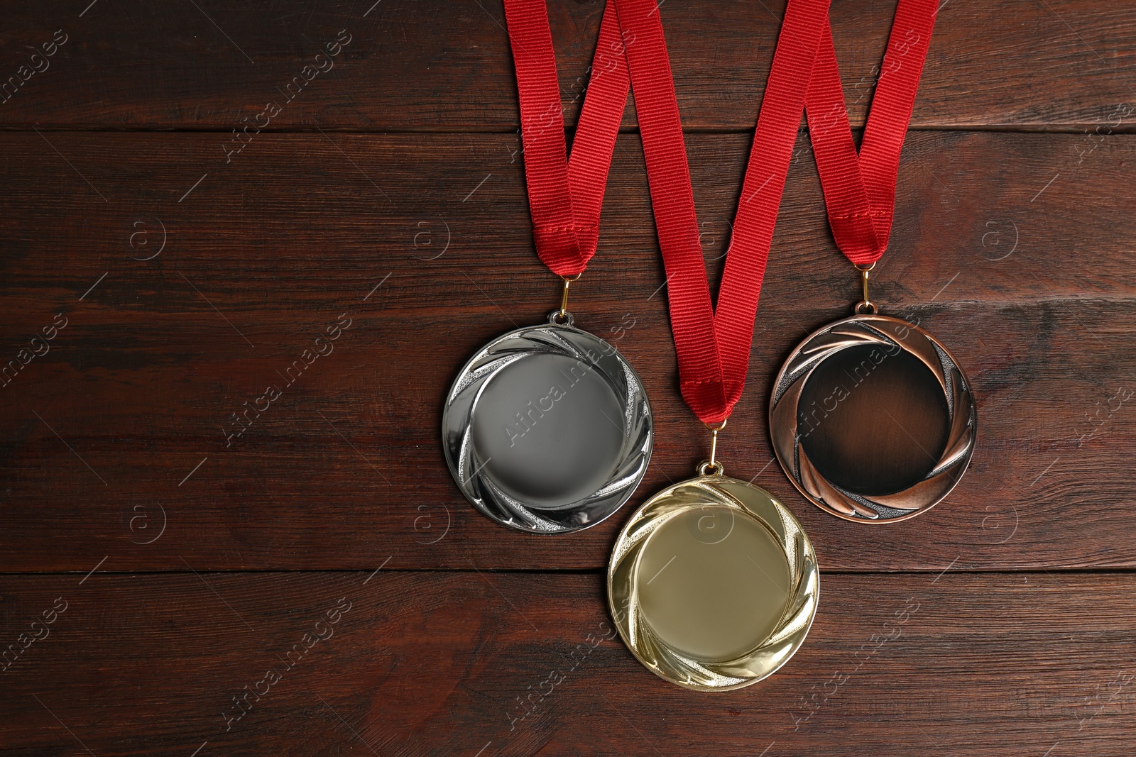 Photo of Gold, silver and bronze medals on wooden background, flat lay. Space for design