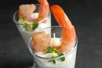 Photo of Glasses with boiled shrimps and sauce on grey background