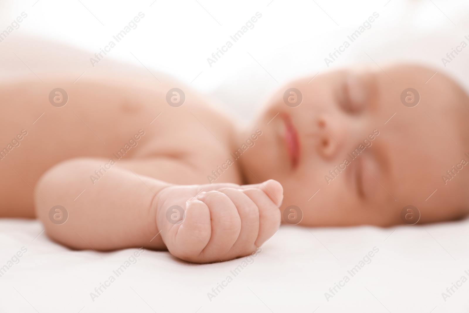 Photo of Cute little baby sleeping at home, focus on hand