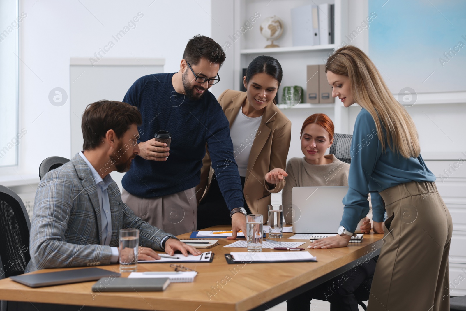 Photo of Team of employees working together in office