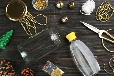 Set of instruments and materials for snow globe on black wooden table, flat lay