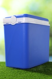 Photo of One plastic cool box on artificial grass, closeup