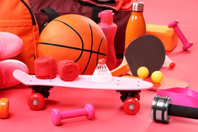 Many different sports equipment on red background