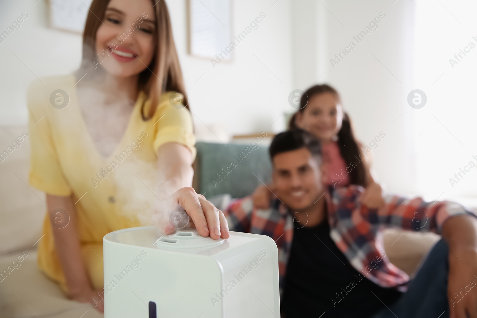 Photo of Family near modern air humidifier at home