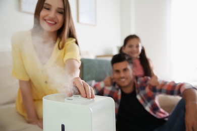 Family near modern air humidifier at home