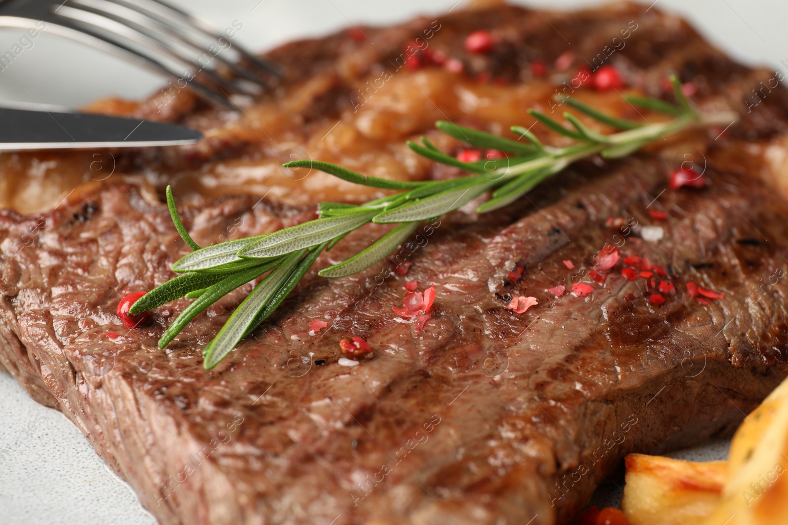 Photo of Delicious grilled beef steak with rosemary on plate, closeup