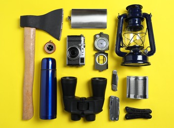 Set of traveler's equipment on yellow background, flat lay