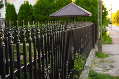 Photo of Beautiful black iron fence near pathway outdoors