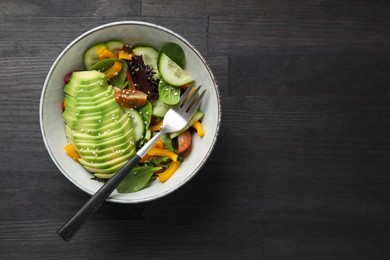 Healthy dish high in vegetable fats on black wooden table, top view. Space for text