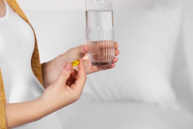 Photo of Pregnant woman taking pill on bed, closeup. Space for text