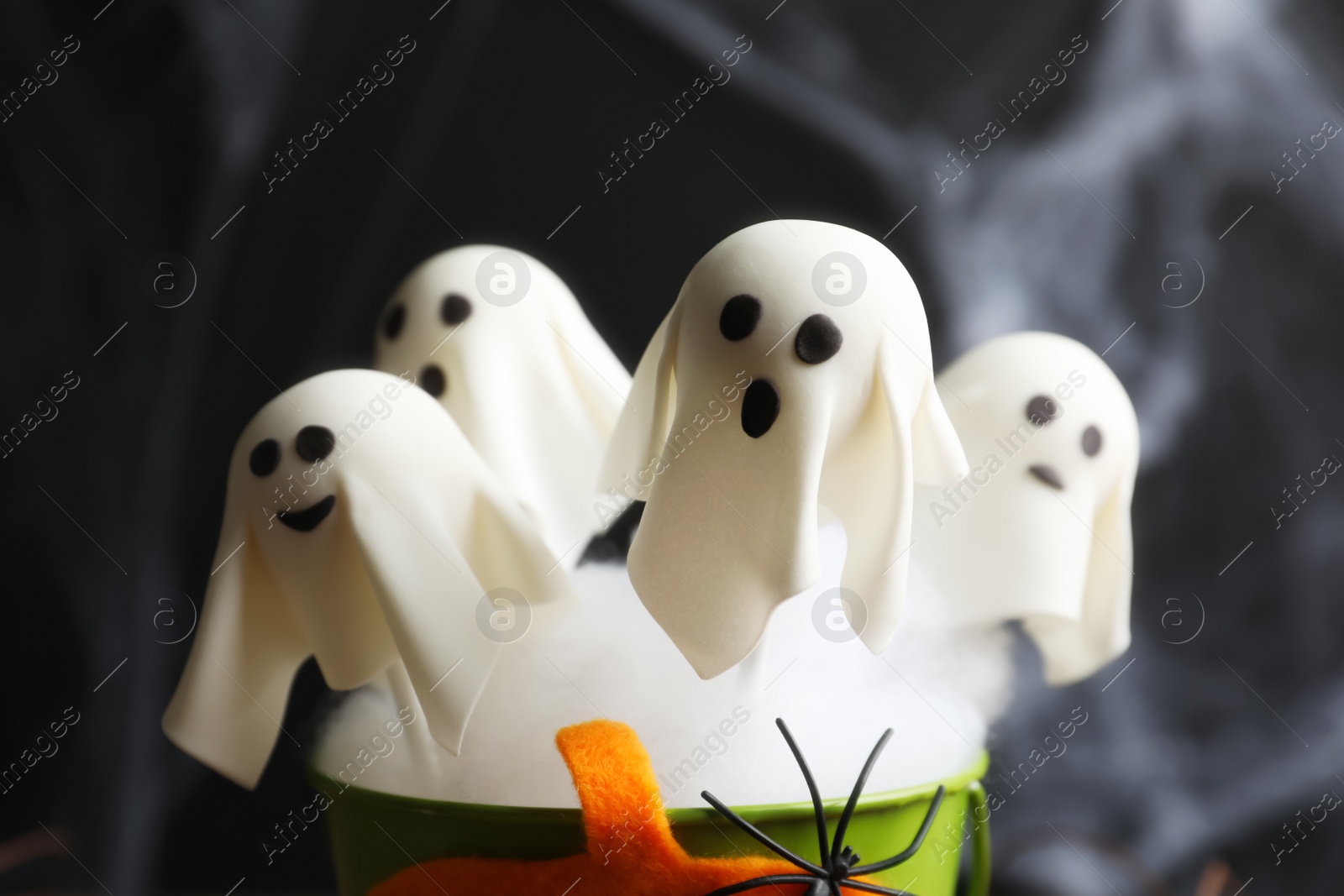 Photo of Ghost shaped cake pops on dark background, closeup. Halloween treat