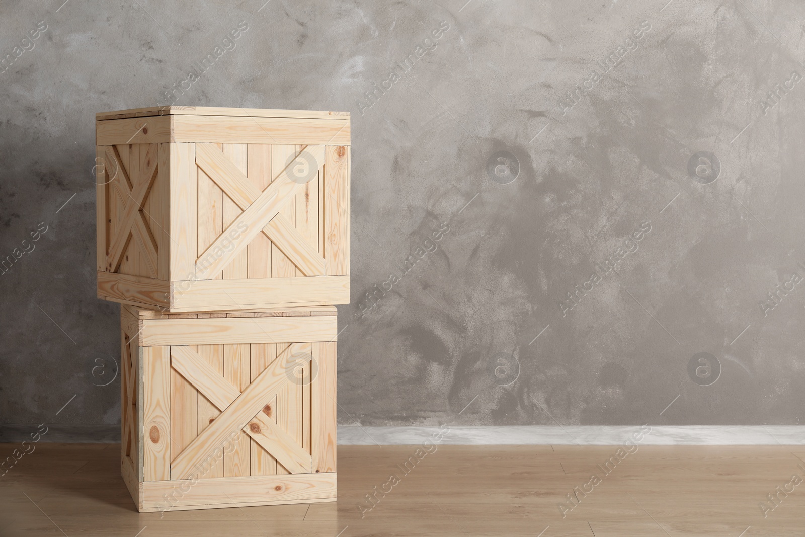 Photo of Wooden crates on floor against color background, space for text