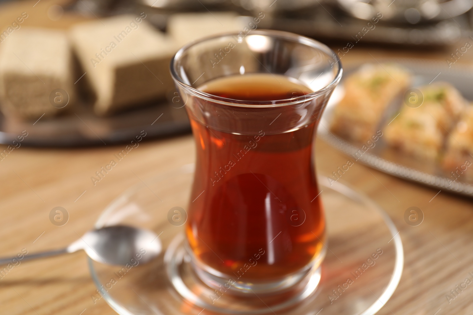 Photo of Traditional Turkish tea in glass on table, closeup