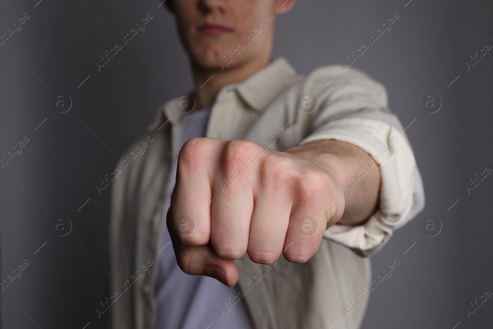 Photo of Man showing fist with space for tattoo on grey background, selective focus
