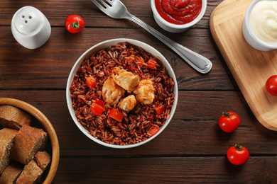 Photo of Delicious brown rice served on wooden table, flat lay