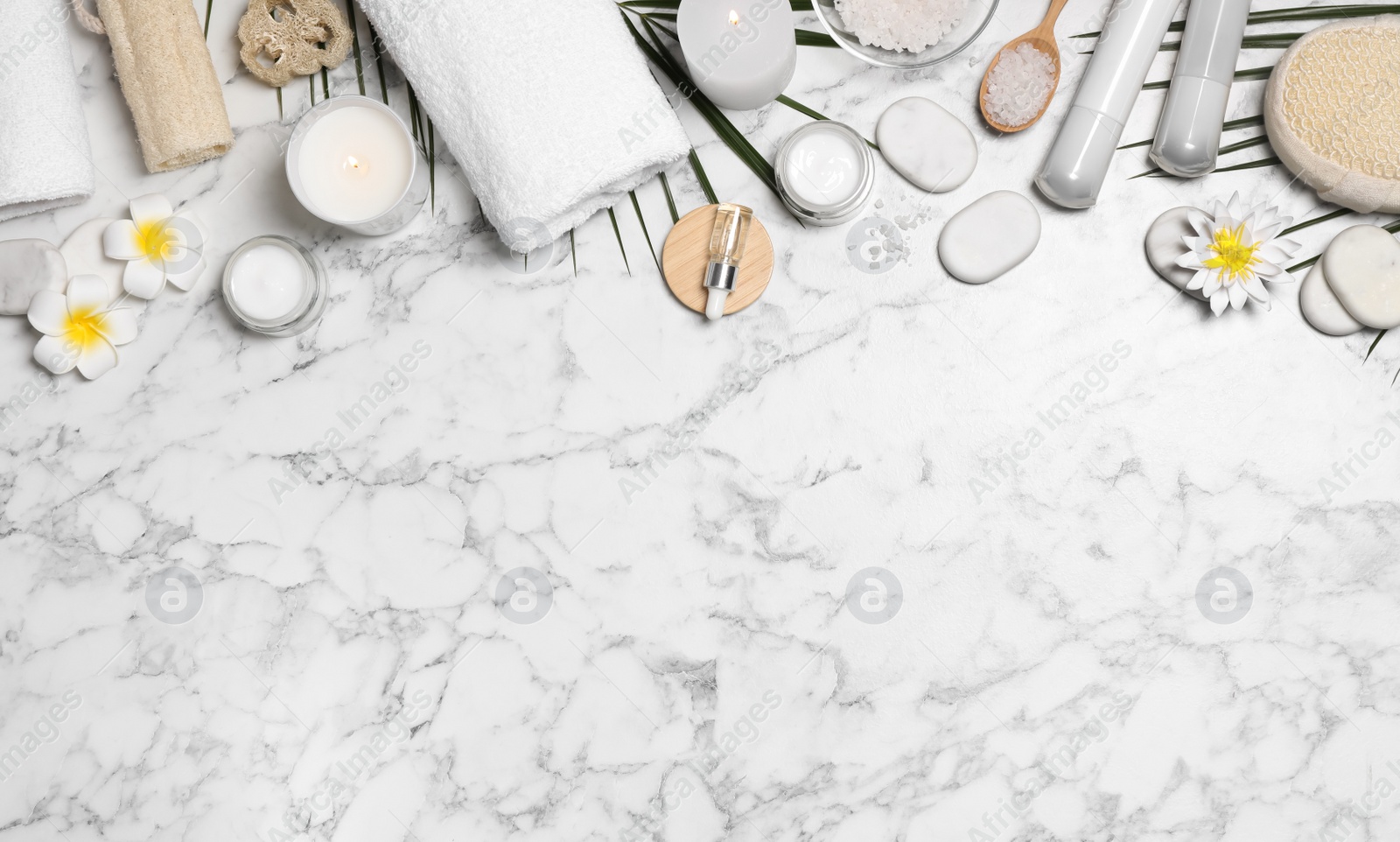 Photo of Flat lay composition with spa essentials on white marble background. Space for text