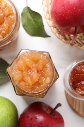Photo of Delicious apple jam and fresh fruits on white table, flat lay