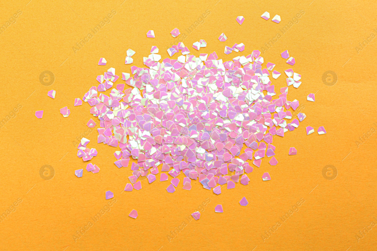 Photo of Shiny bright pink glitter on yellow background