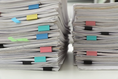 Photo of Stacks of documents with paper clips on office desk, closeup
