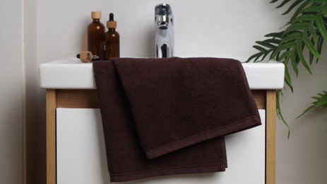 Photo of Brown soft towel on sink in bathroom