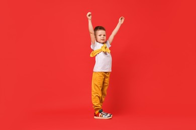 Happy little boy dancing on red background