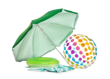 Open green beach umbrella, inflatable toys and blanket on white background