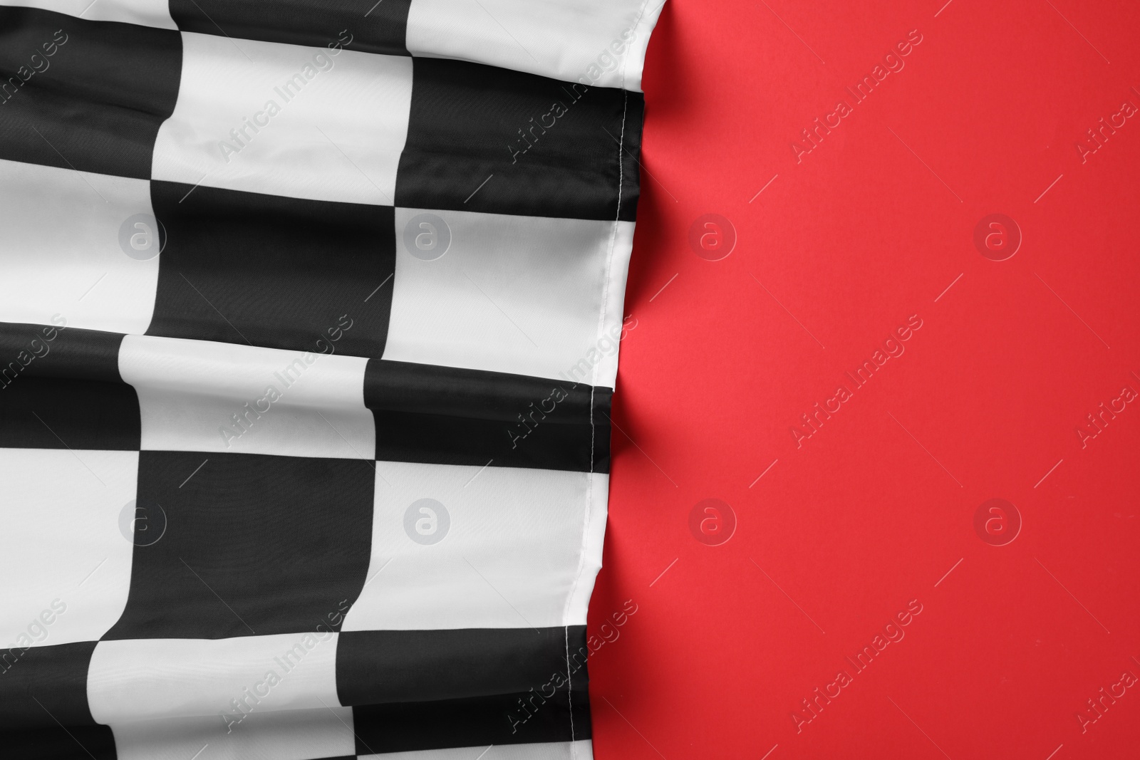 Photo of Racing checkered flag on red background, top view. Space for text