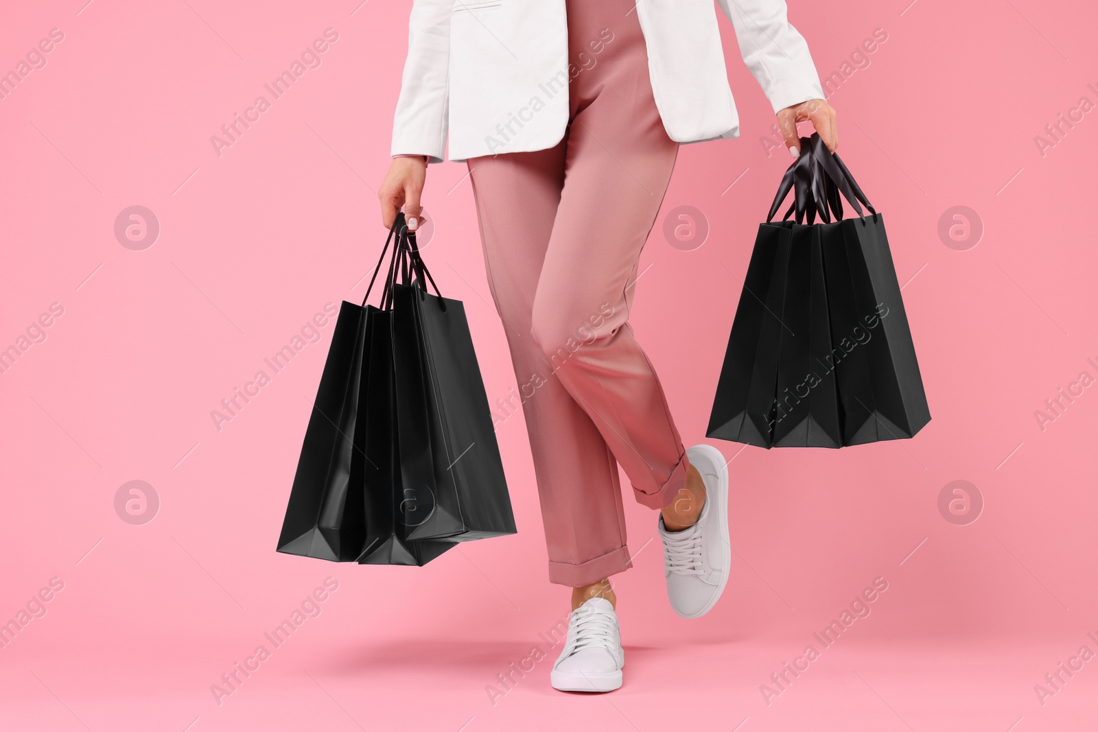 Photo of Woman with shopping bags on pink background, closeup