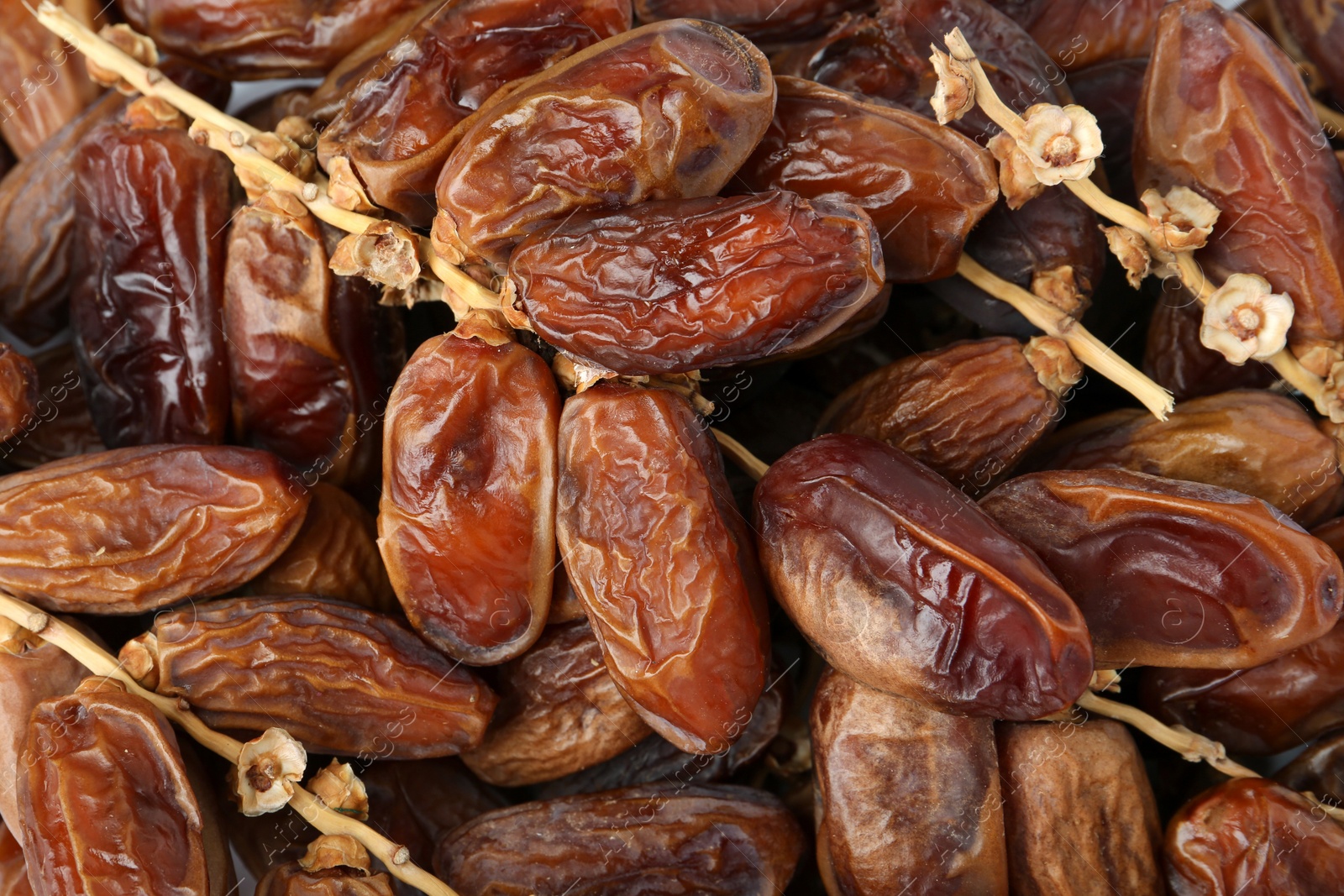 Photo of Sweet dried dates on branches as background, top view. Healthy snack