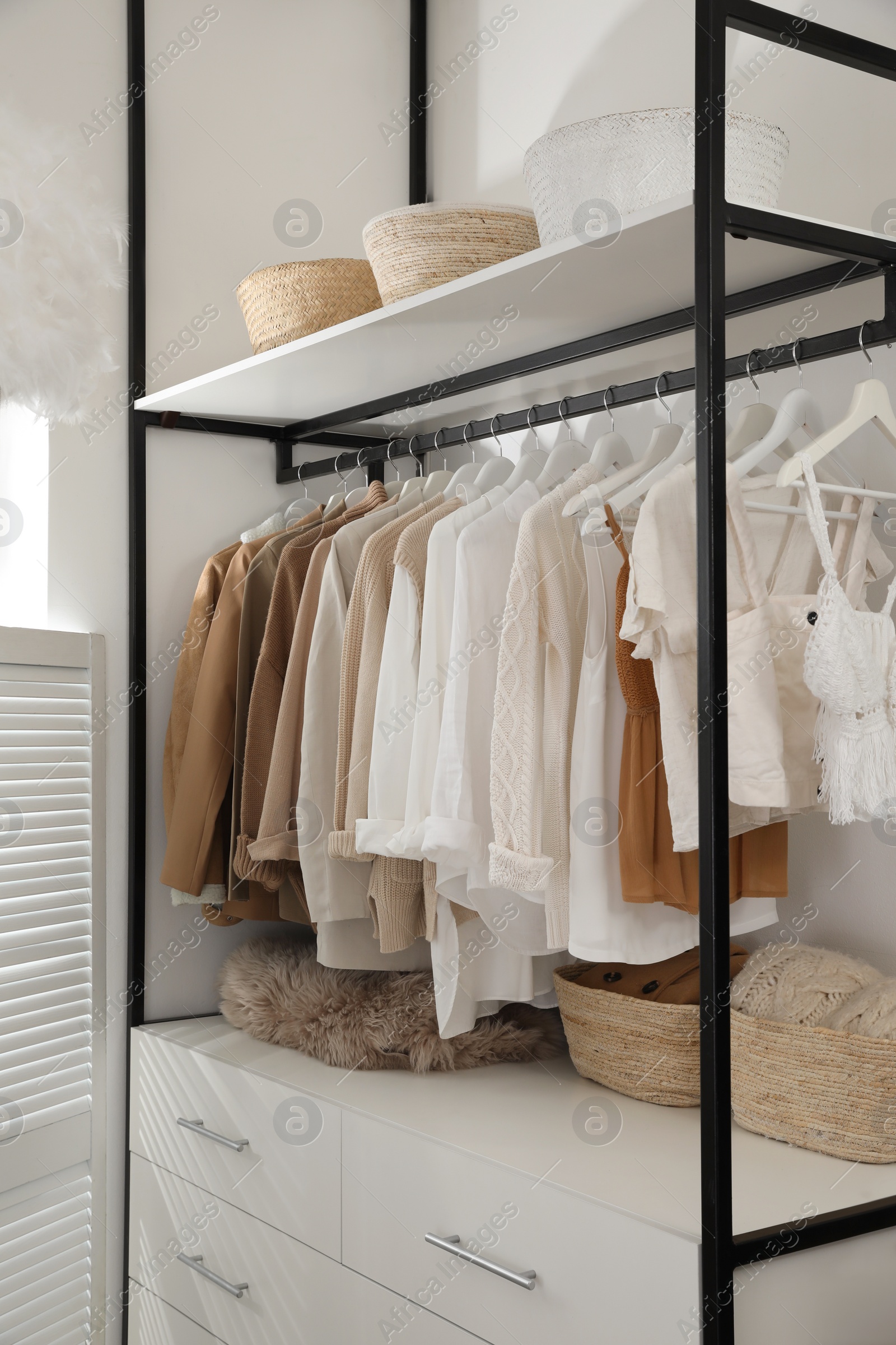 Photo of Rack with stylish women's clothes in dressing room