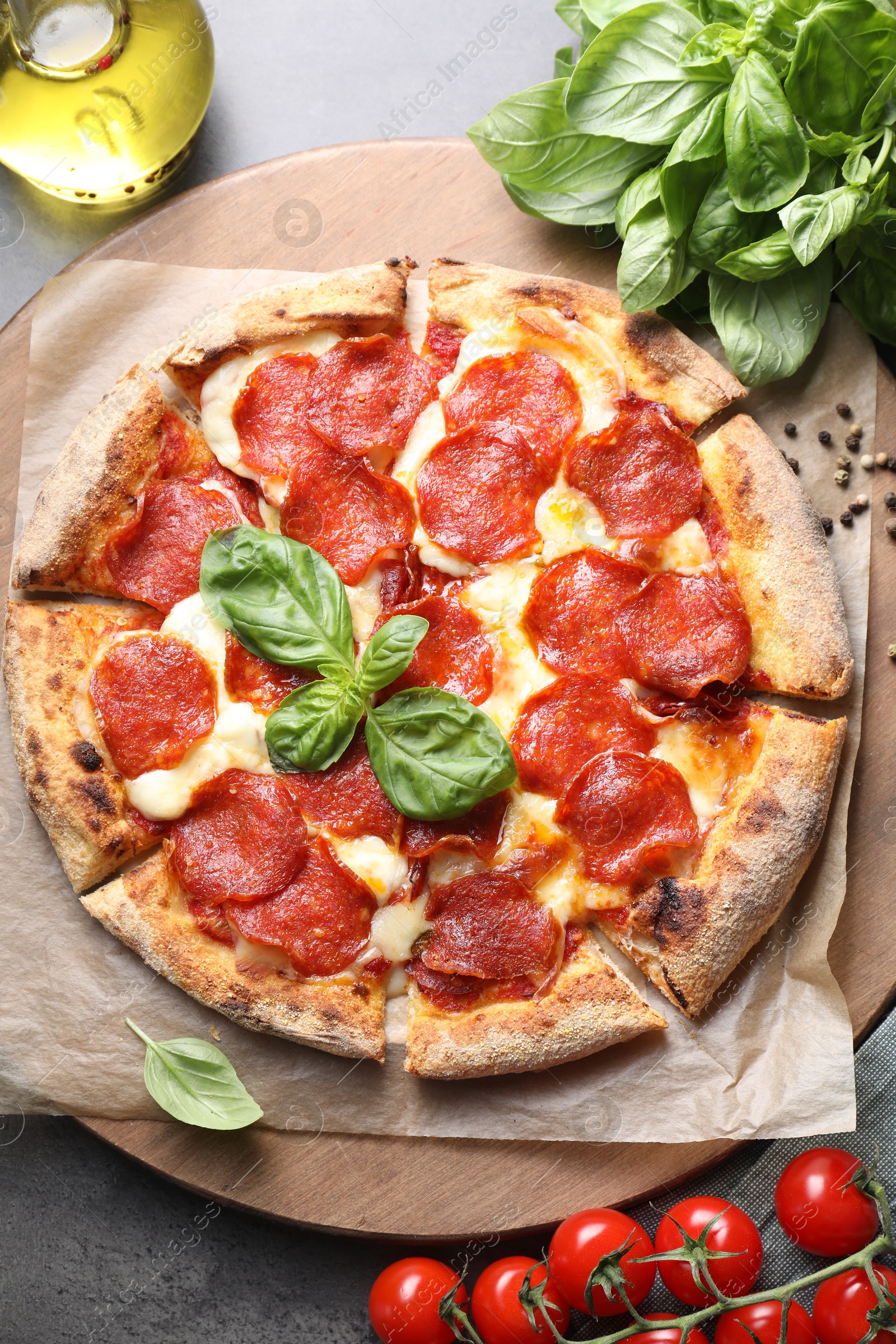 Photo of Tasty pepperoni pizza and ingredients on grey table, top view