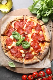 Tasty pepperoni pizza and ingredients on grey table, top view