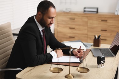 Photo of Confident lawyer working at table in office