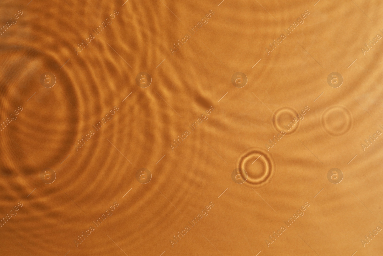 Photo of Closeup view of water with circles on brown background